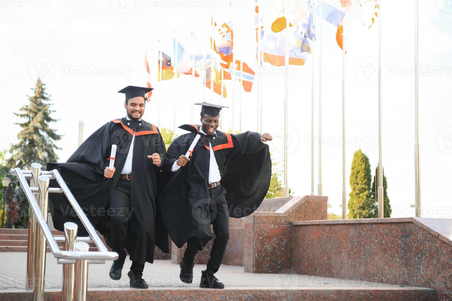Group of multiracial graduate students with diplomas on university background photo