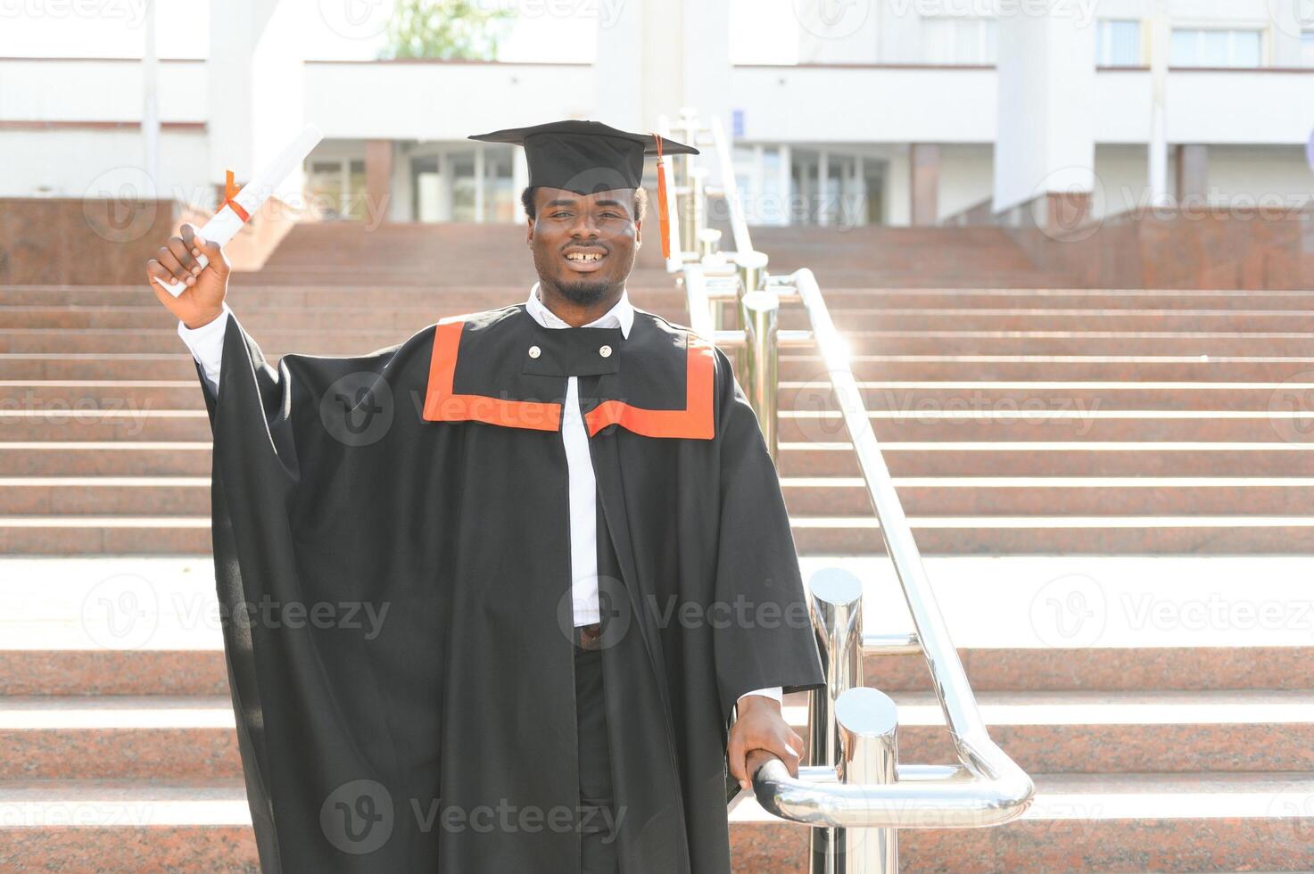 smiling african american graduated student showing diploma photo