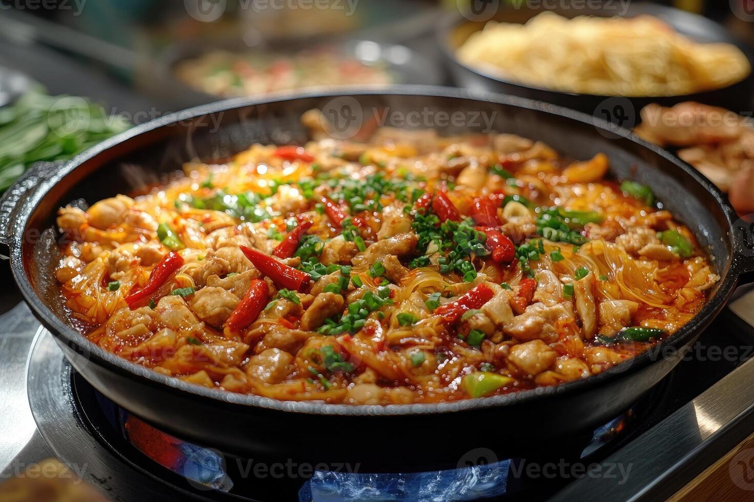 Spicy korean food dakgalbi steaming in a hot stone bowl photo
