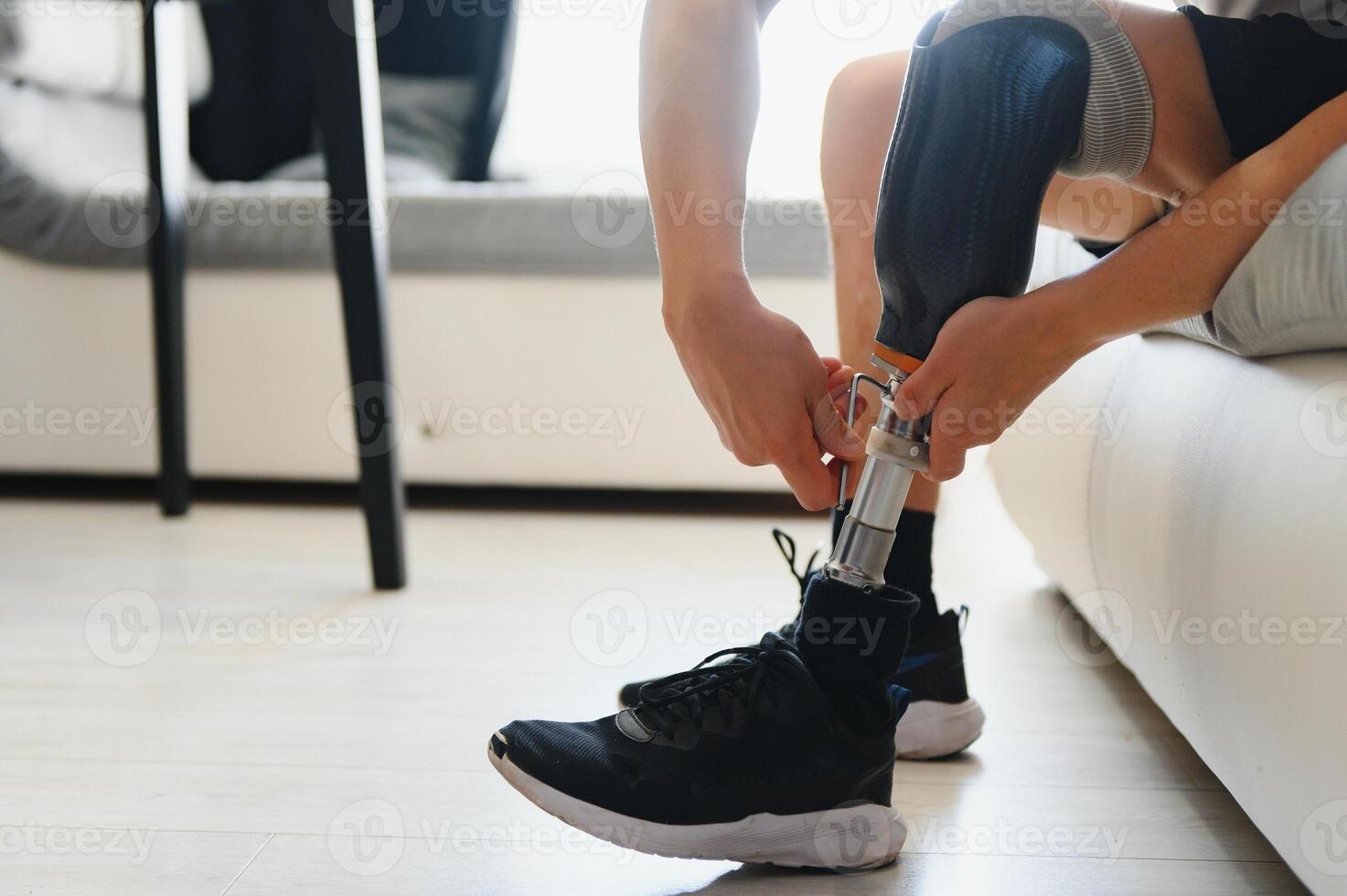 Unrecognizable man with bionic prosthetic leg at home indoors, copy space photo