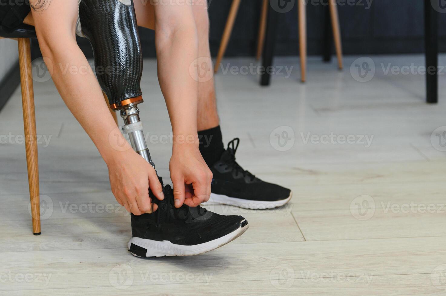 Closeup of unrecognizable man with bionic prosthetic leg at home indoors, copy space photo