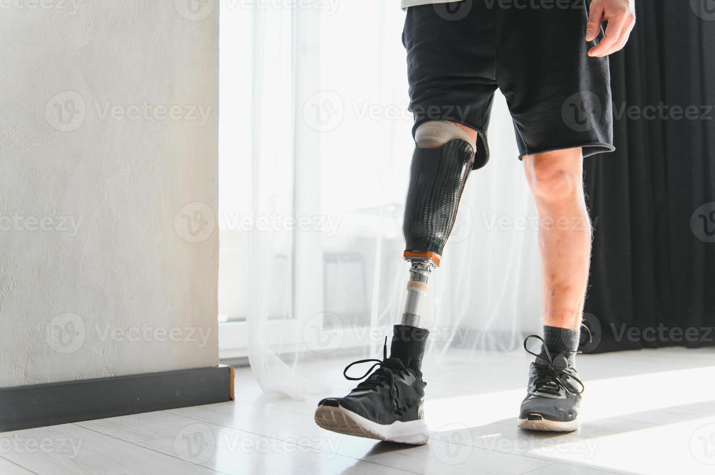 Unrecognizable man with bionic prosthetic leg at home indoors, copy space photo
