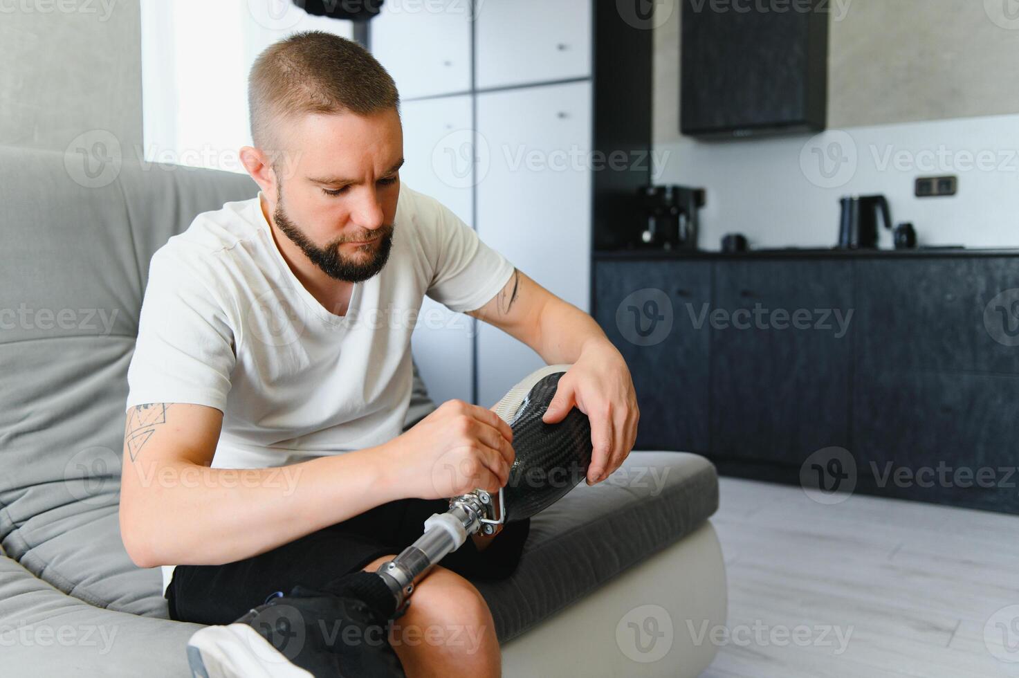 portrait of man with prosthetic leg sitting photo