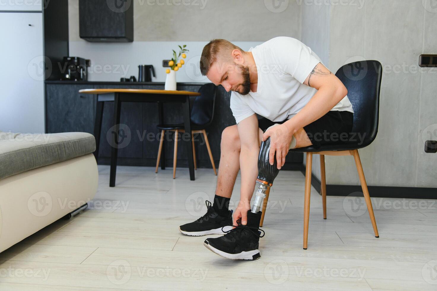 Unrecognizable man with bionic prosthetic leg at home indoors, copy space photo