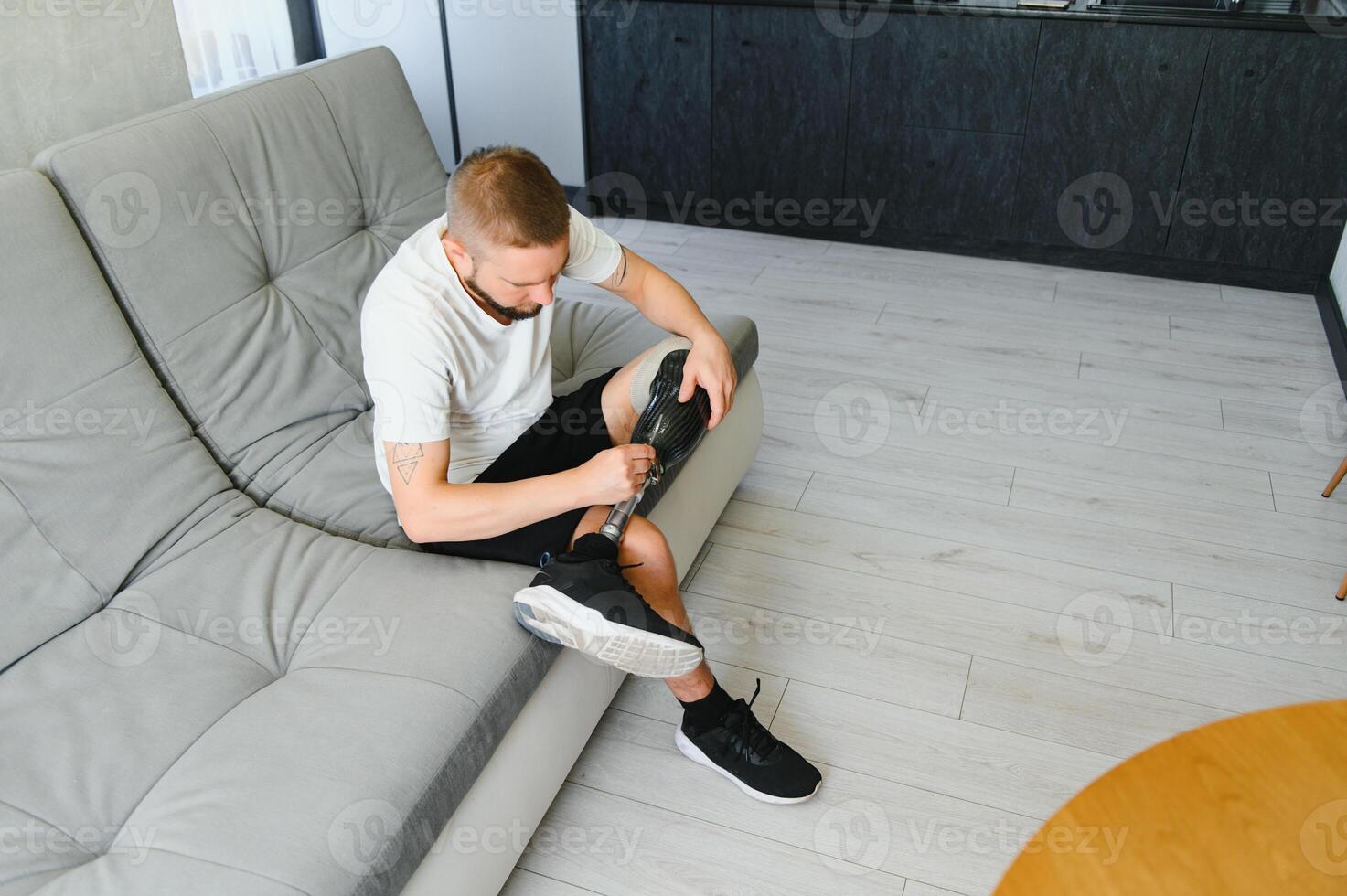 Man amputee with prosthetic leg disability on above knee transfemoral leg prosthesis artificial device, close up. People with amputation disabilities everyday life photo
