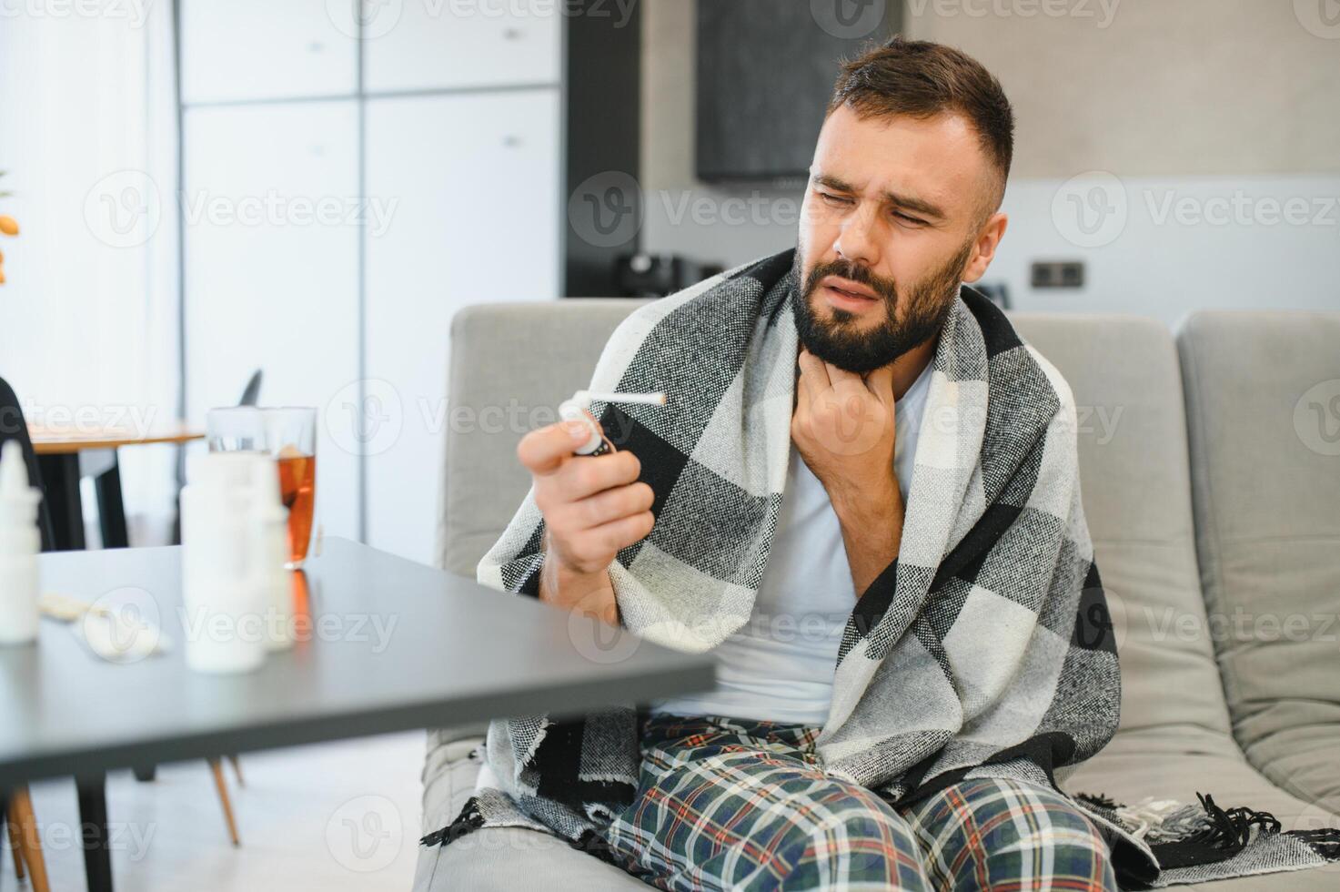 Sick man holding his chest in pain while coughing in the living room. Sore throat and cough, man with lung pain at home, health problems concept photo