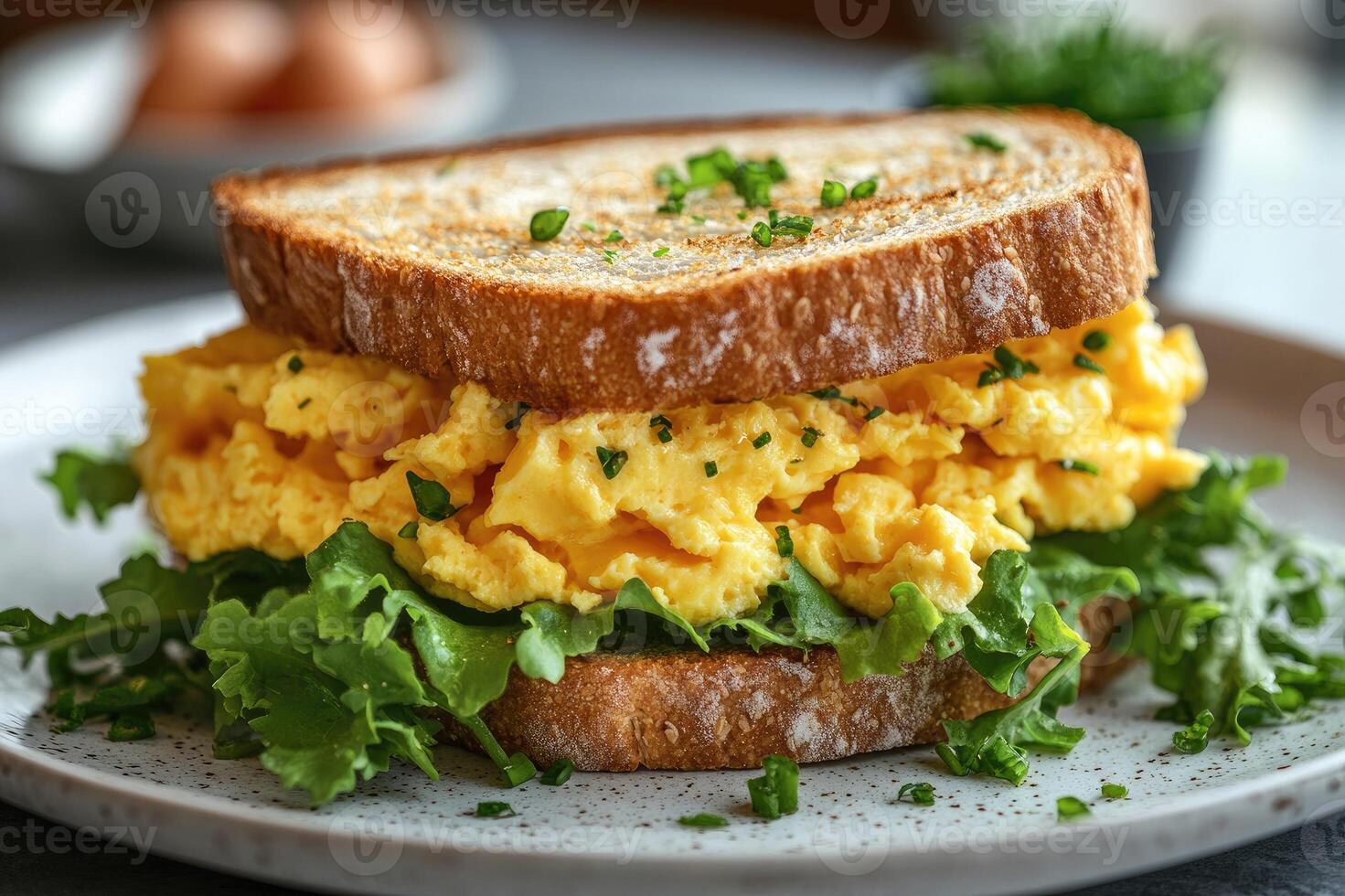 Delicious scrambled eggs sandwich with toasted bread and greens for breakfast photo