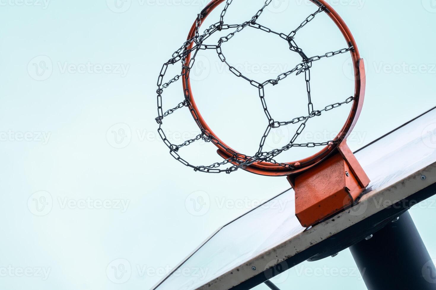 Basketball hoop with metal chain net against clear sky. photo