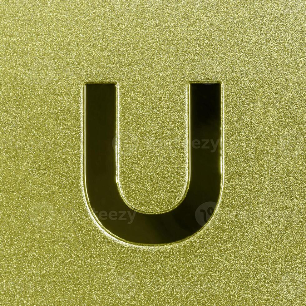 Letter U on a golden grained shiny metal surface. English alphabet. photo