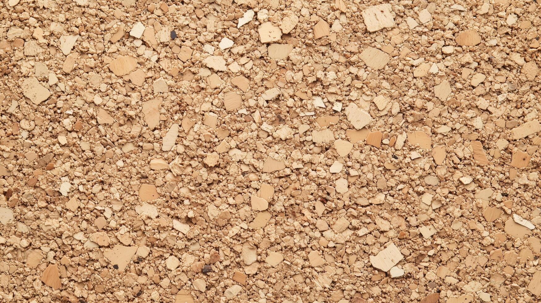 A close up of a tan colored surface with many small pieces of material. photo
