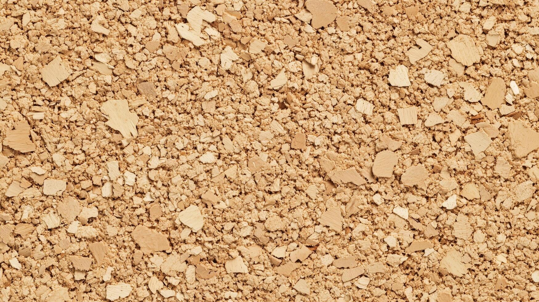 A close up of a tan colored surface with many small pieces of material. photo