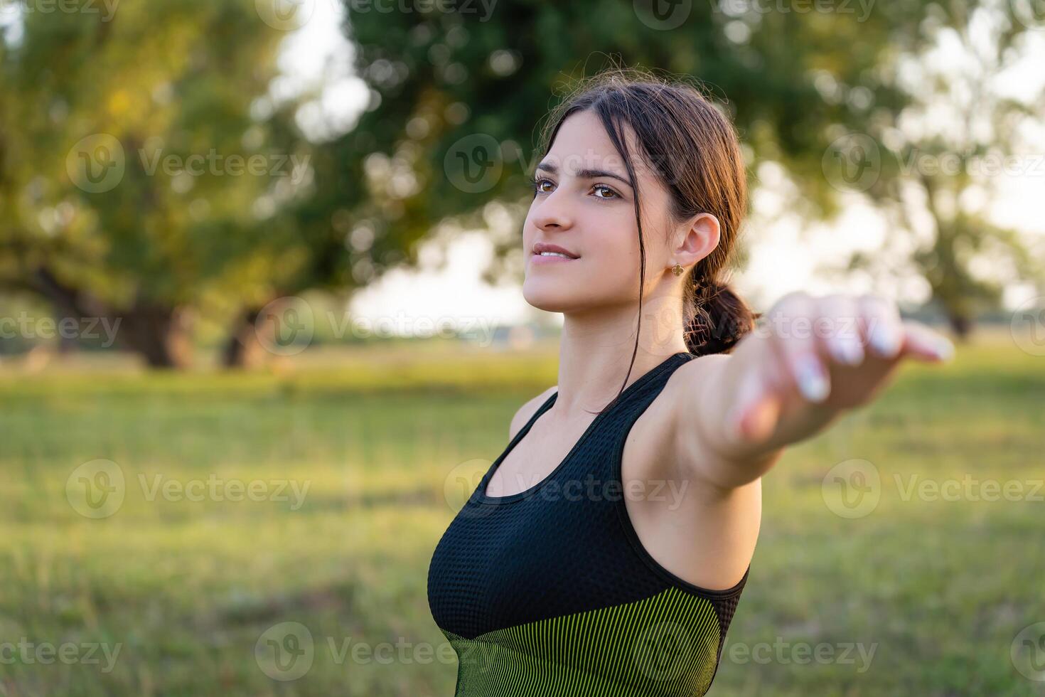 girl stands sideways to the camera in the process of doing exercises and physical activity. Her slender and toned figure as a dedication to a healthy lifestyle and physical development photo