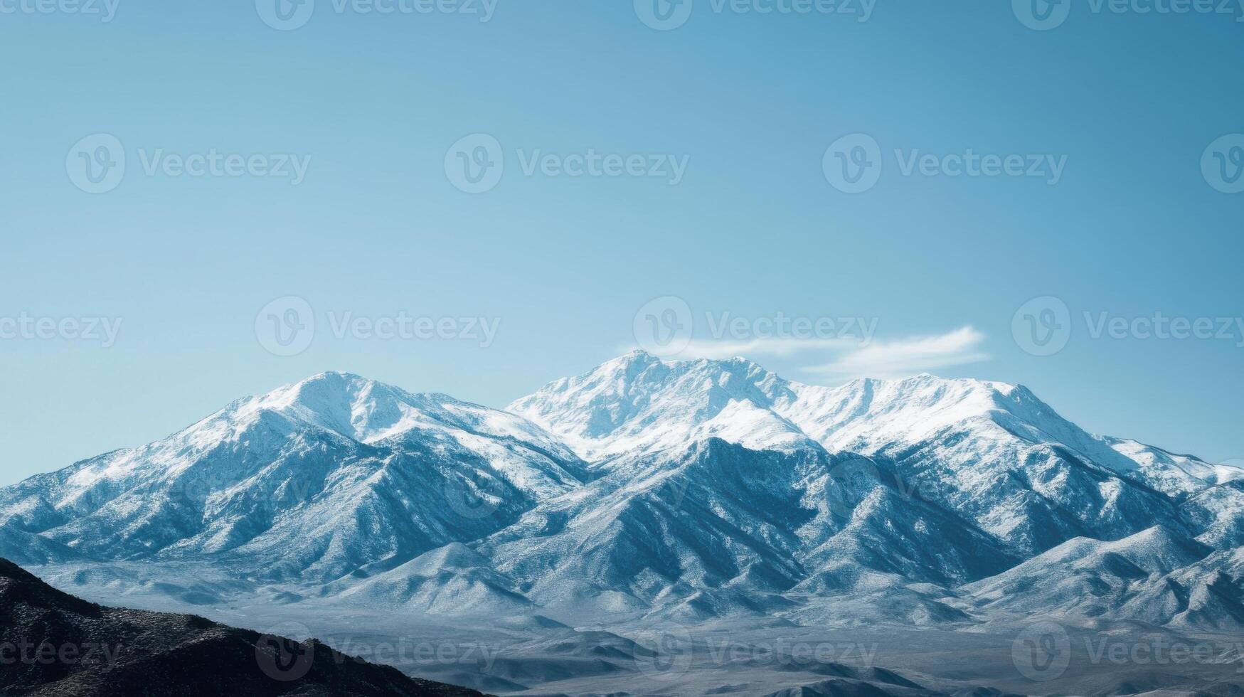 The mountains are covered in snow and the sky is clear and blue photo