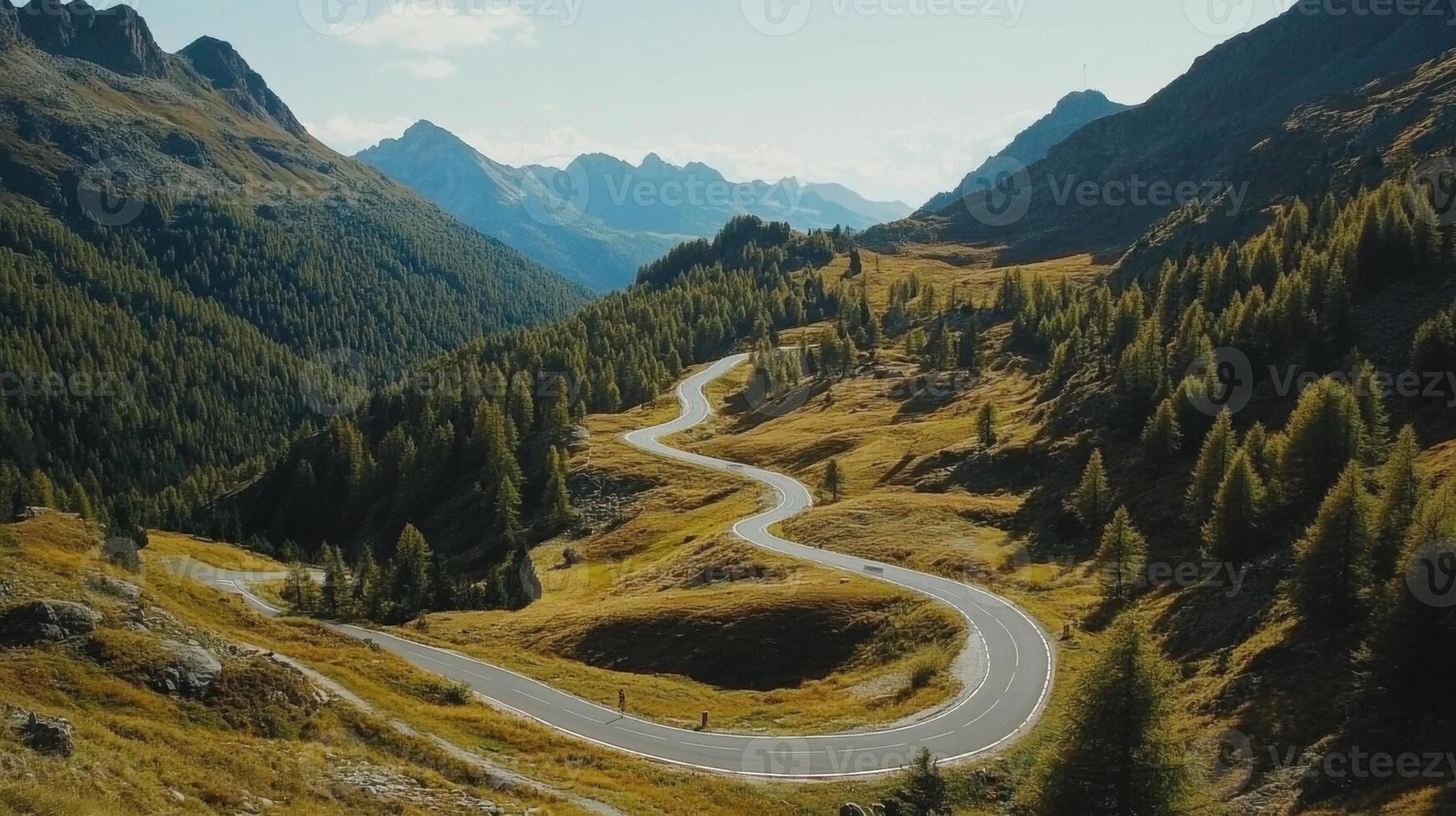 A winding road in the mountains with trees on both sides photo
