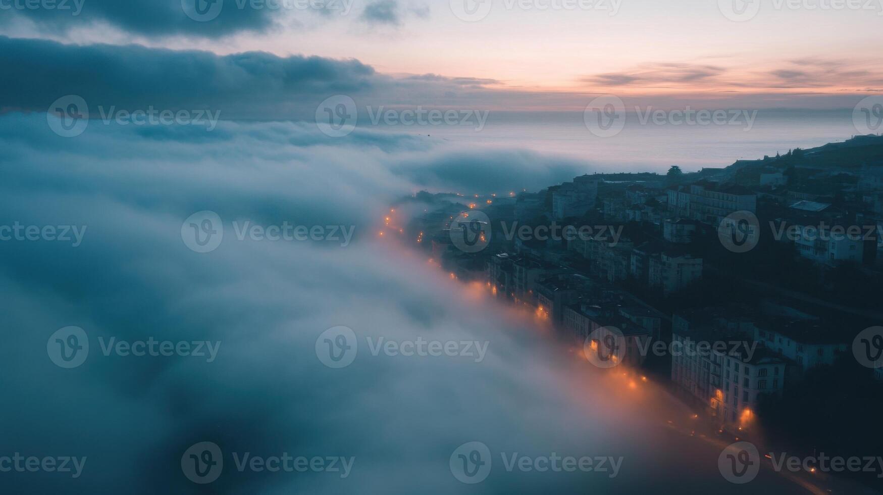 A foggy cityscape with a cloudy sky and a sunset in the background photo