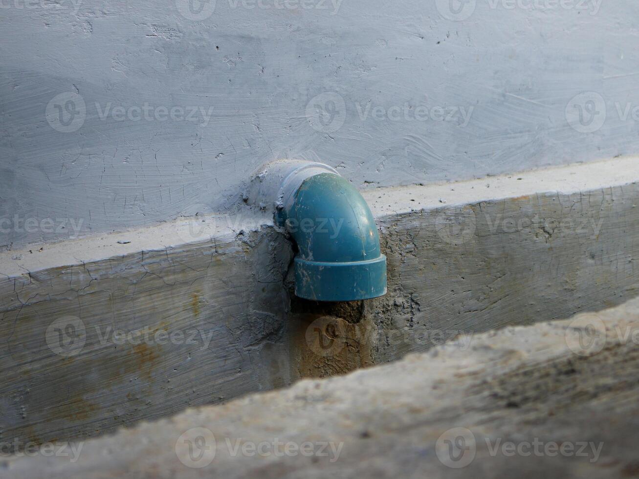 Water dripping from a drain pipe in a ditch photo