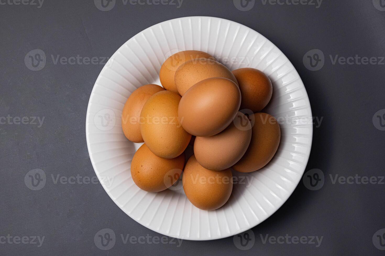 Chicken eggs in plate isolated on grey background with clipping path. Close up with selective focus photo