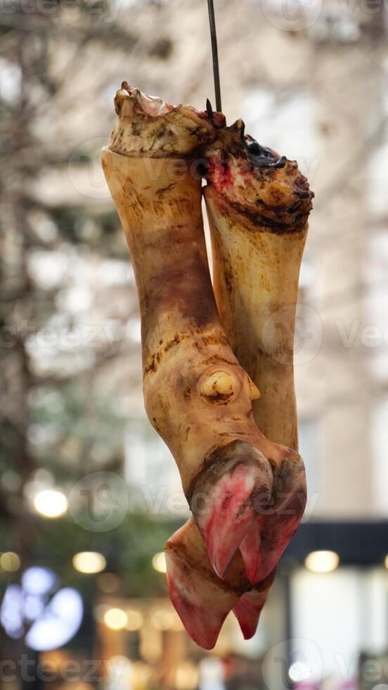 Raw Animal Hooves Hanging in a Market photo