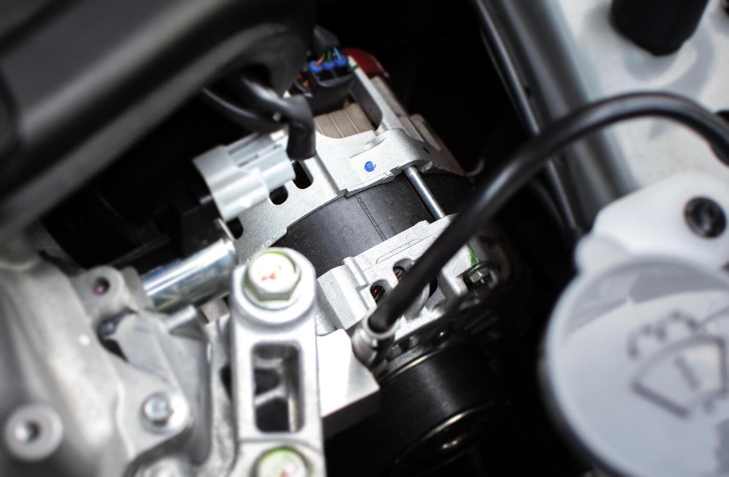 Close up of car generator or alternator in engine compartment, car spare parts concept photo