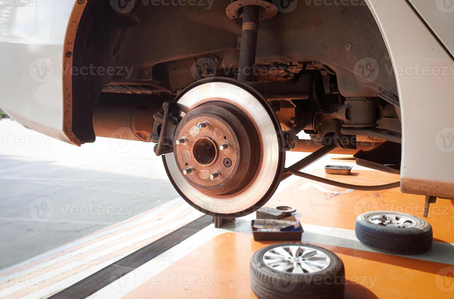 Rear braking system with disc brakes and calipers , Lifting a car without wheels for repairing in an auto repair shop , car repair concept photo