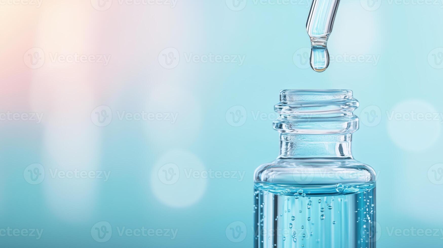 A close-up of a glass bottle with a dropper, showcasing a water drop ready to fall, on a soft blue background. photo