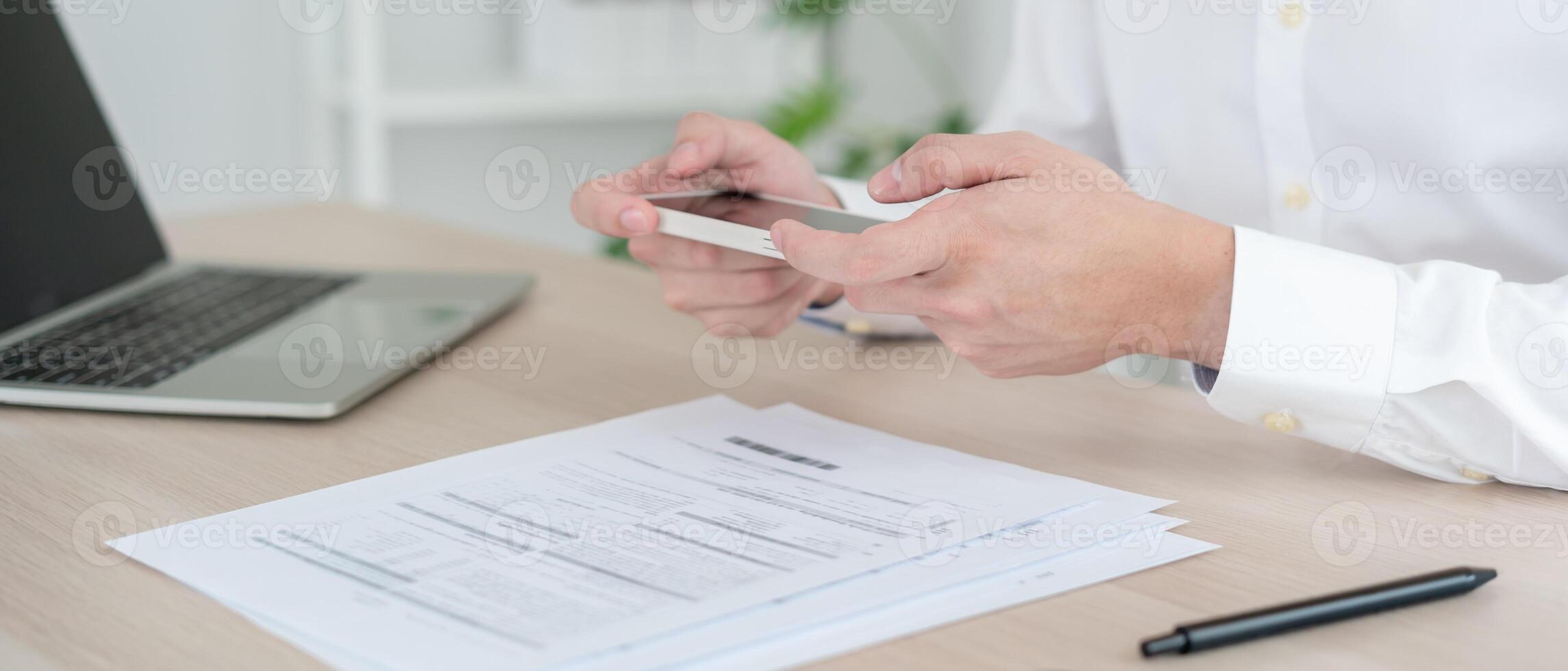 business man use phone to scan barcode or QR codes to pay credit card bill after receiving document invoice online. payment, receive, paying electricity, digital payments without money, technology photo