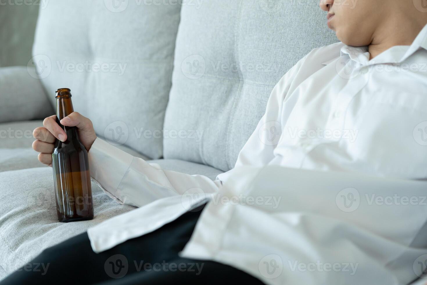 Depressed young business man addicted feeling bad drinking whiskey alone at home, stressed frustrated lonely drinking alcohol suffers from problematic liquor, alcoholism, life and family problems photo