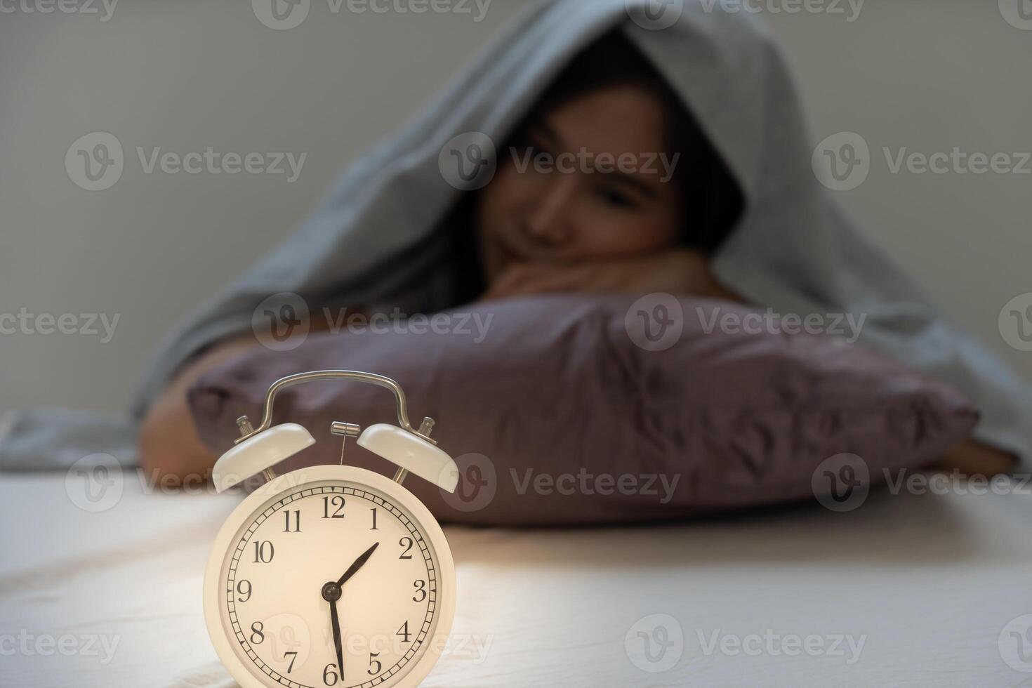 asian woman in bed late trying to sleep suffering insomnia, sleepless or scared in a nightmare, looking sad worried and stressed. Tired and headache or migraine waking up in the middle of the night. photo