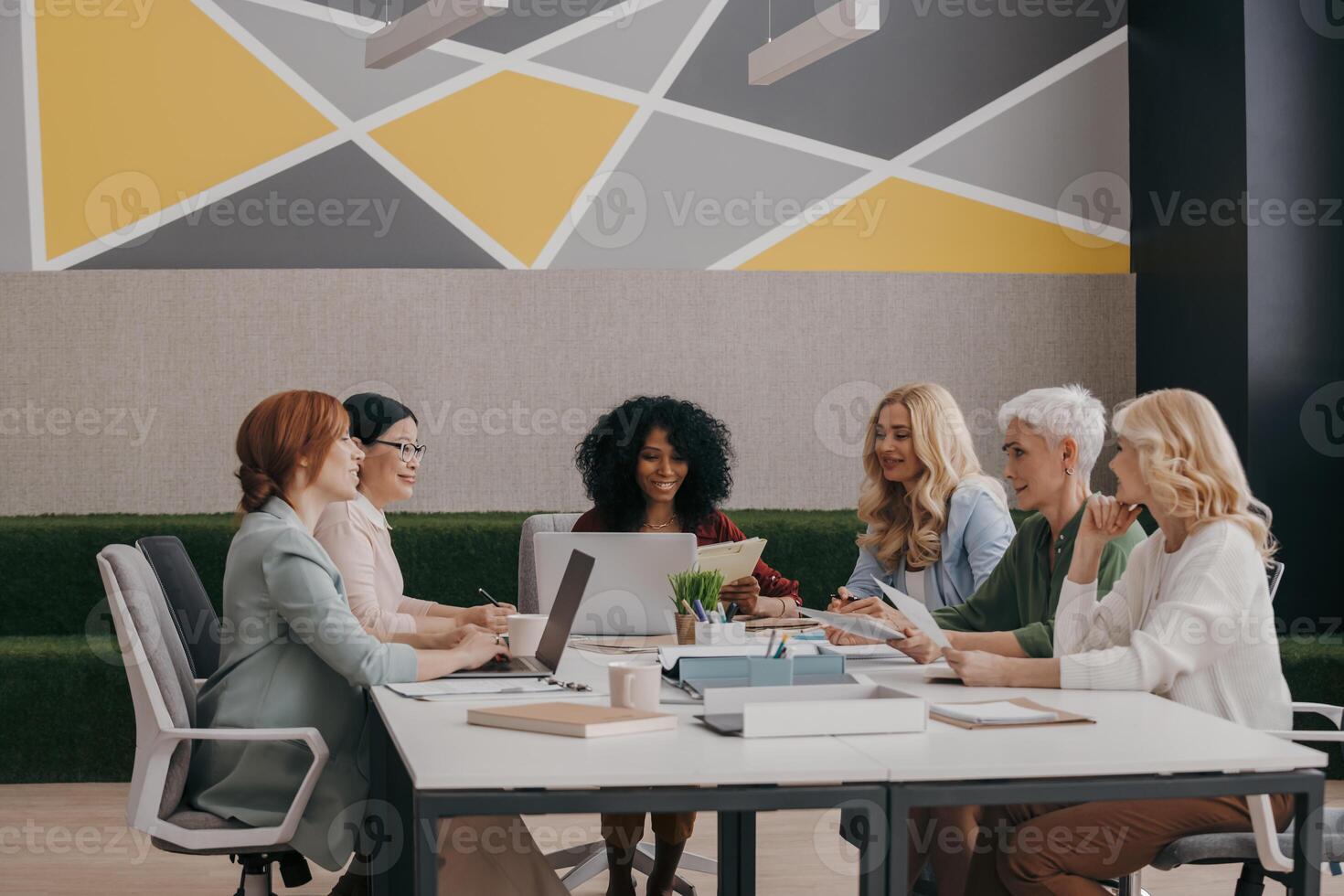 Group of confident mature women discussing business while having meeting in the office photo