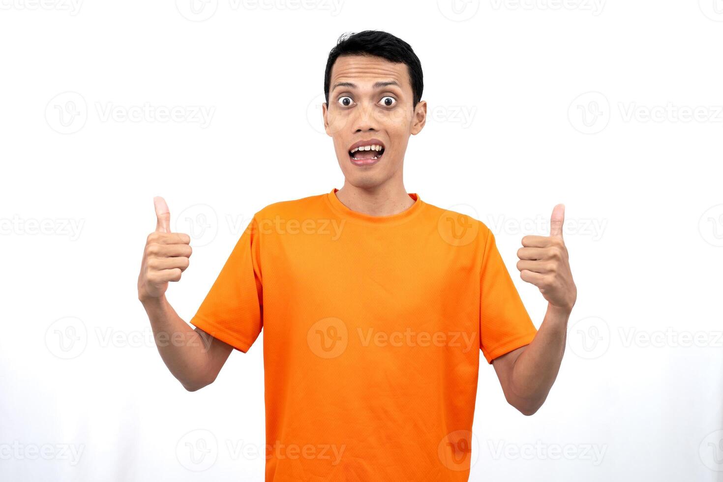 Portrait of a young Asian man wearing an orange t-shirt giving a thumbs up, okay, agree sign. isolated on white background. photo