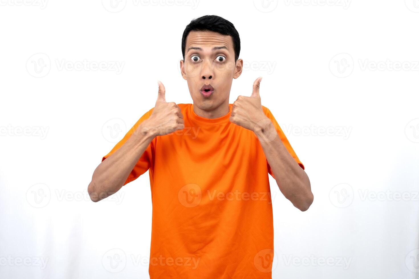 Portrait of a young Asian man wearing an orange t-shirt giving a thumbs up, okay, agree sign. isolated on white background. photo