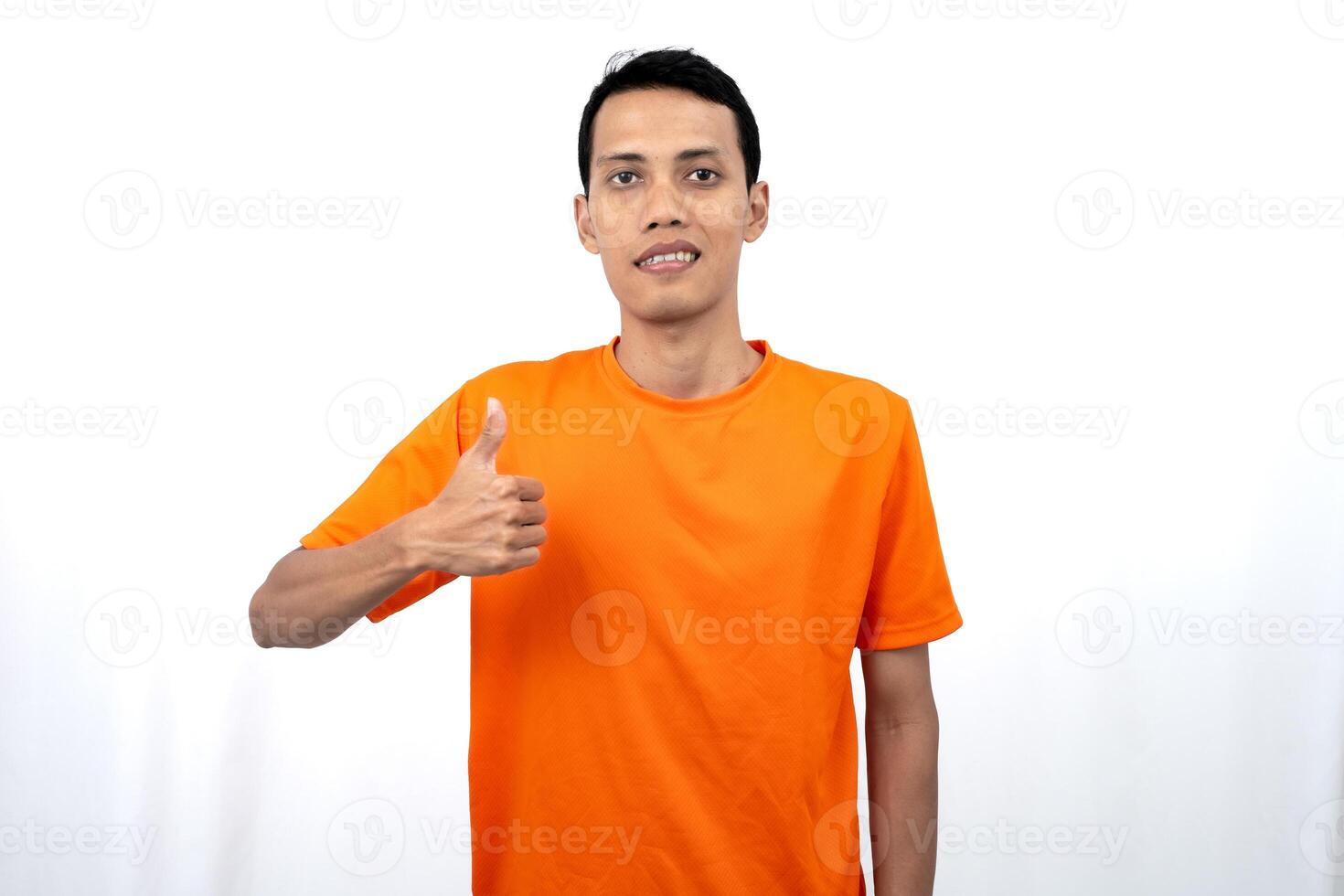 Portrait of a young Asian man wearing an orange t-shirt giving a thumbs up, okay, agree sign. isolated on white background. photo