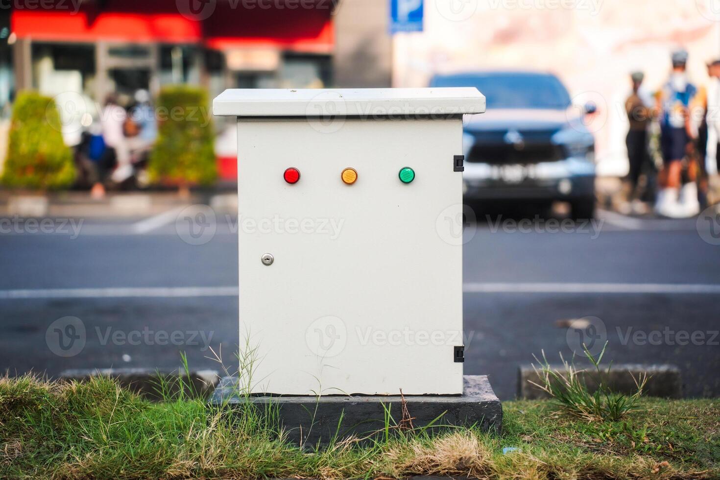 medium sized electrical panel box located outdoors, in a parking lot or garden. photo