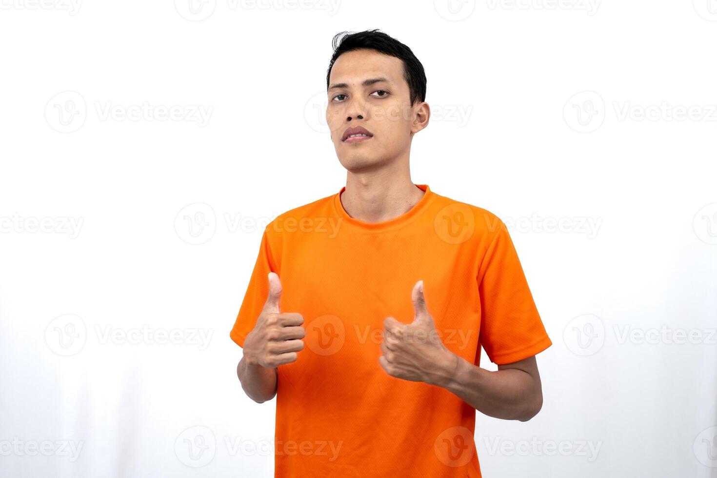 Portrait of a young Asian man wearing an orange t-shirt giving a thumbs up, okay, agree sign. isolated on white background. photo
