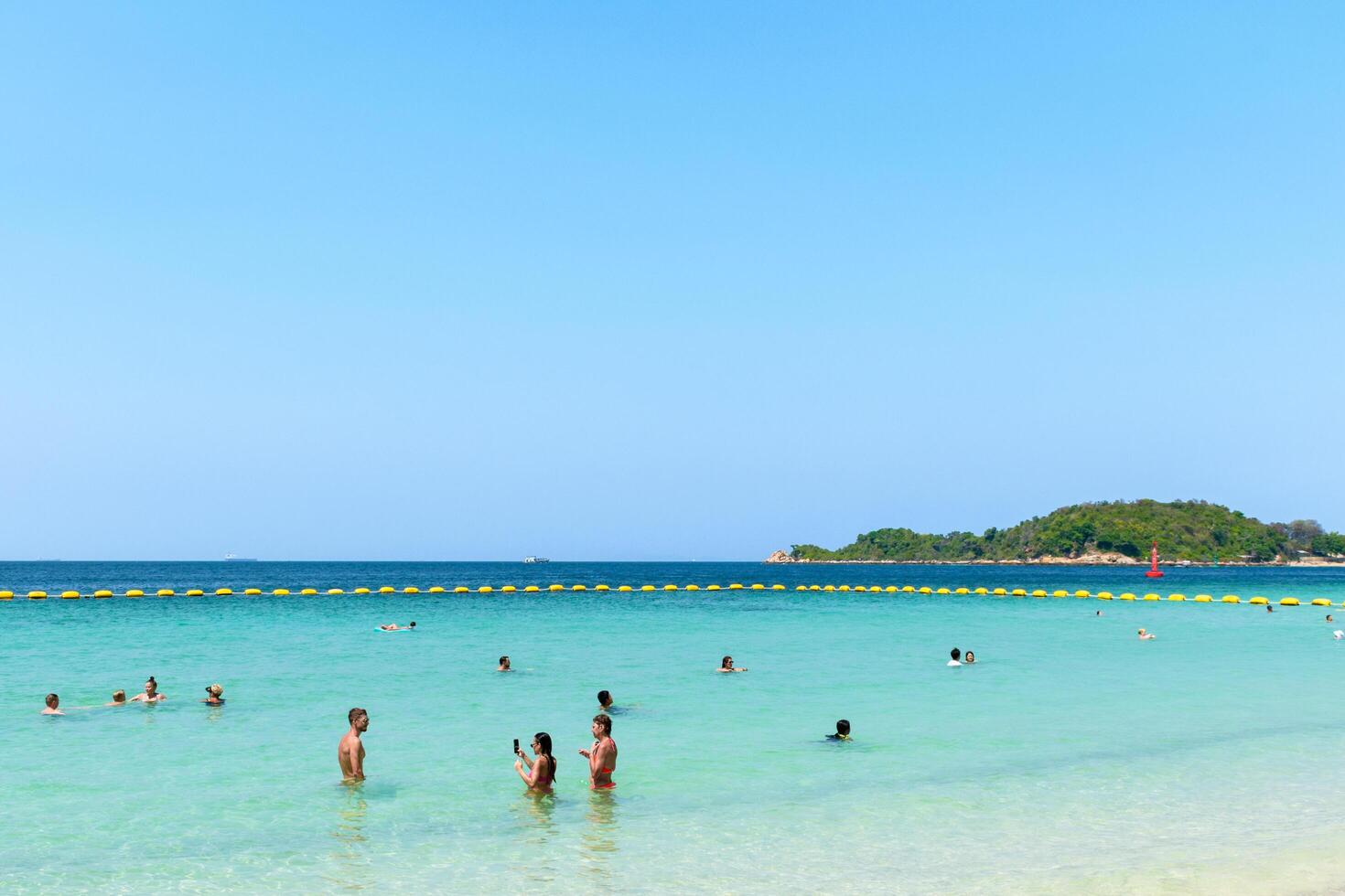 Pattaya, Thailand - March 7, 2024, Landscape of a Tropical beach and Blue sea on Koh Larn island. Group of Tourist or Traveler or many people on the beach. Vacation, Summer, Holiday, Nature, Relax. photo