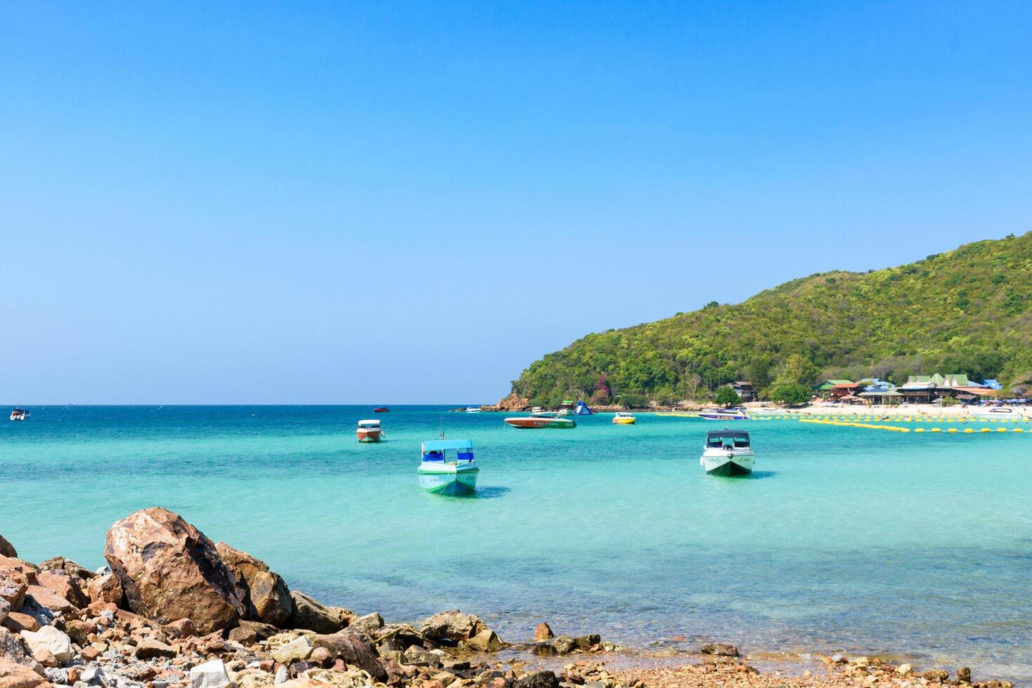 Pattaya, Thailand - March 7, 2024, Landscape of a Tropical beach and Blue sea at Koh Larn island. Group of Tourist or Traveler on the beach. Vacation, Summer, Holiday, Speedboat, Ship, Activity. photo