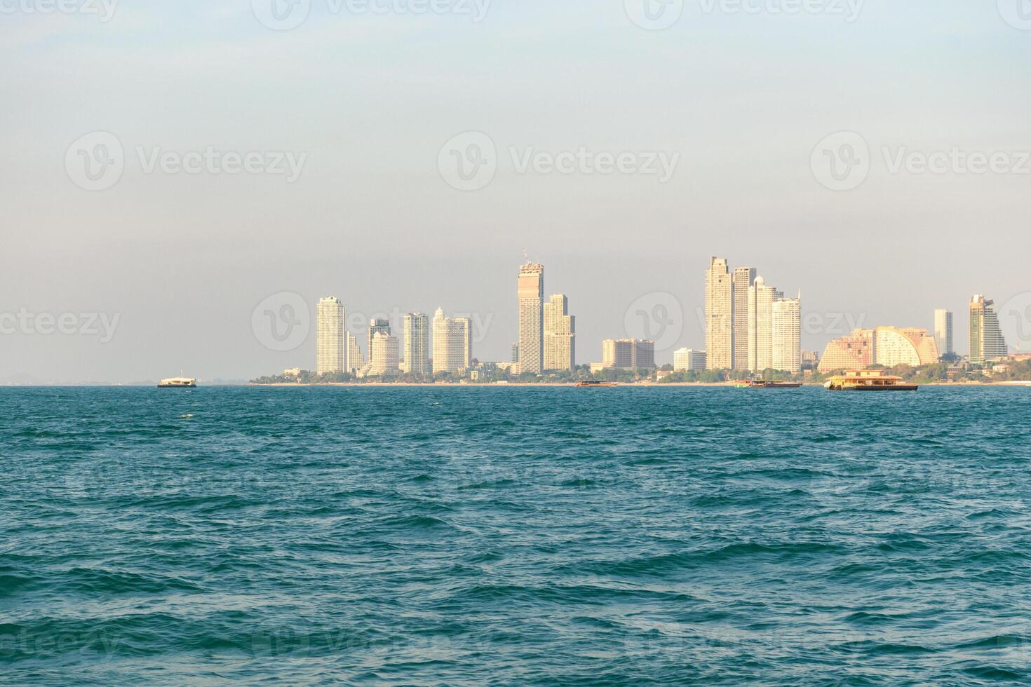 Speedboat or Ship on Blue sea at Koh Larn island on sunset sky and Pattaya cityscape view background. Vacation, Summer, Holiday, Relax, Activity. photo