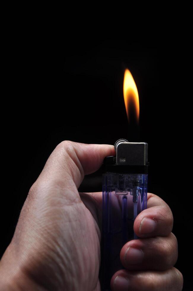 Turn on a gasoline lighter on a black background photo