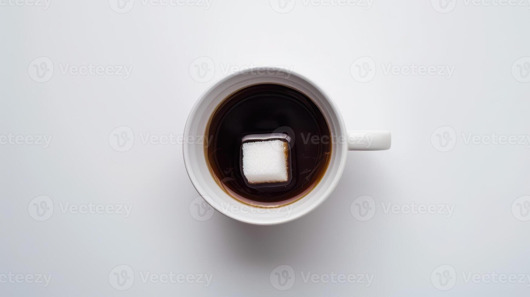 Lone sugar cube rests on the surface of a cup of black coffee in a white mug on a clean white table photo
