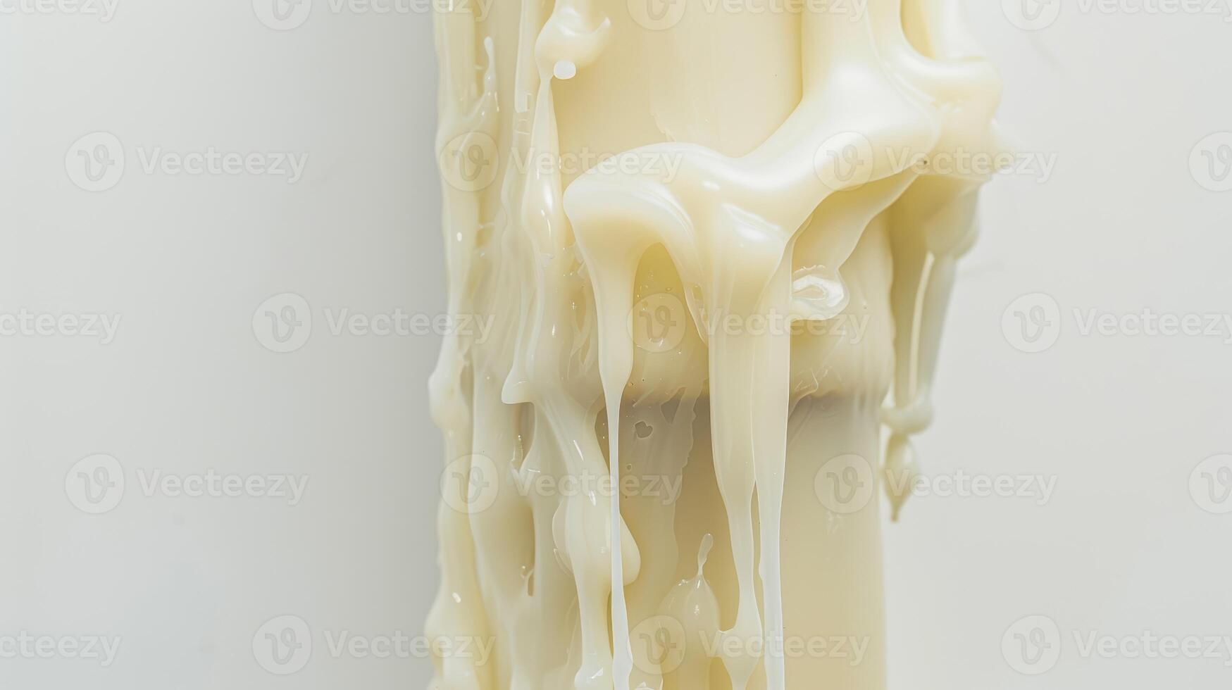 White candle melts, forming intriguing patterns as the wax drips down the side photo