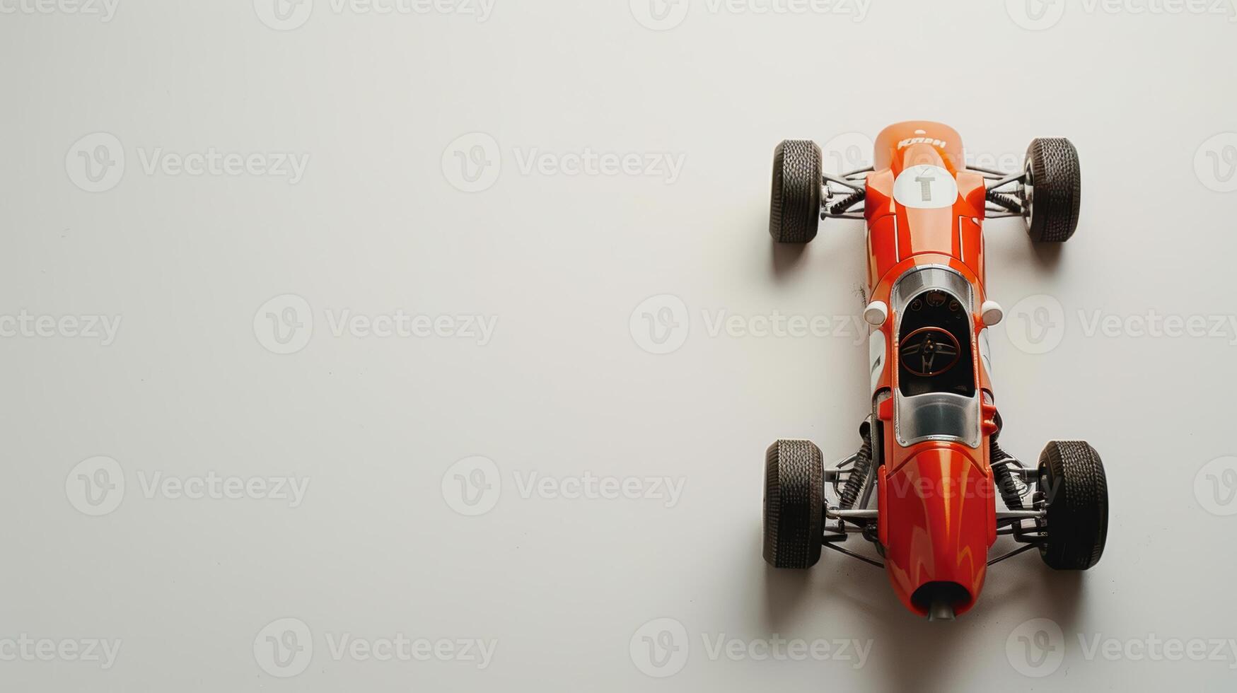 Vintage orange toy racing car on white background, invoking nostalgia and the excitement of speed photo