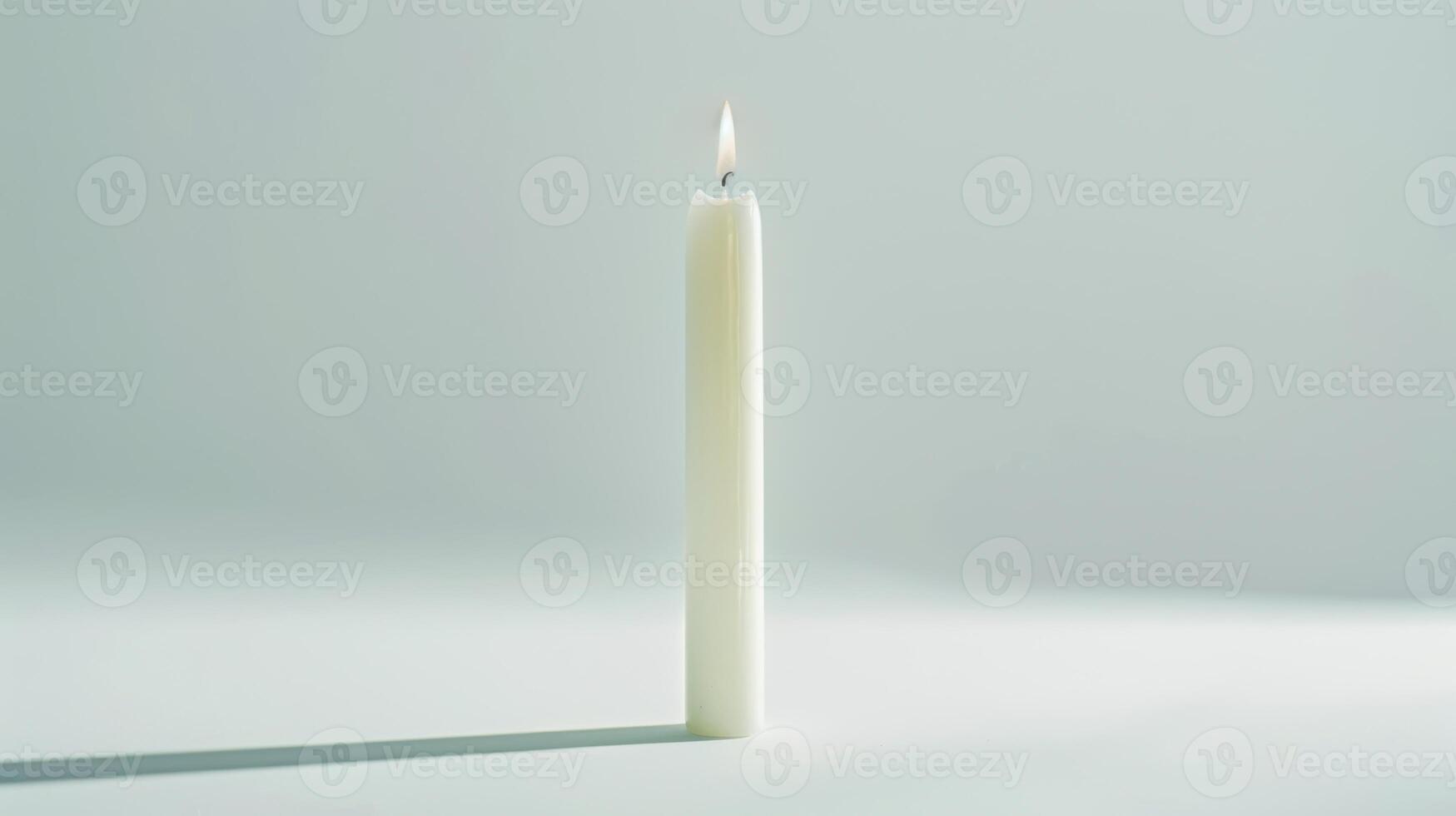 Serene scene with a single white candle burning against a pure background photo