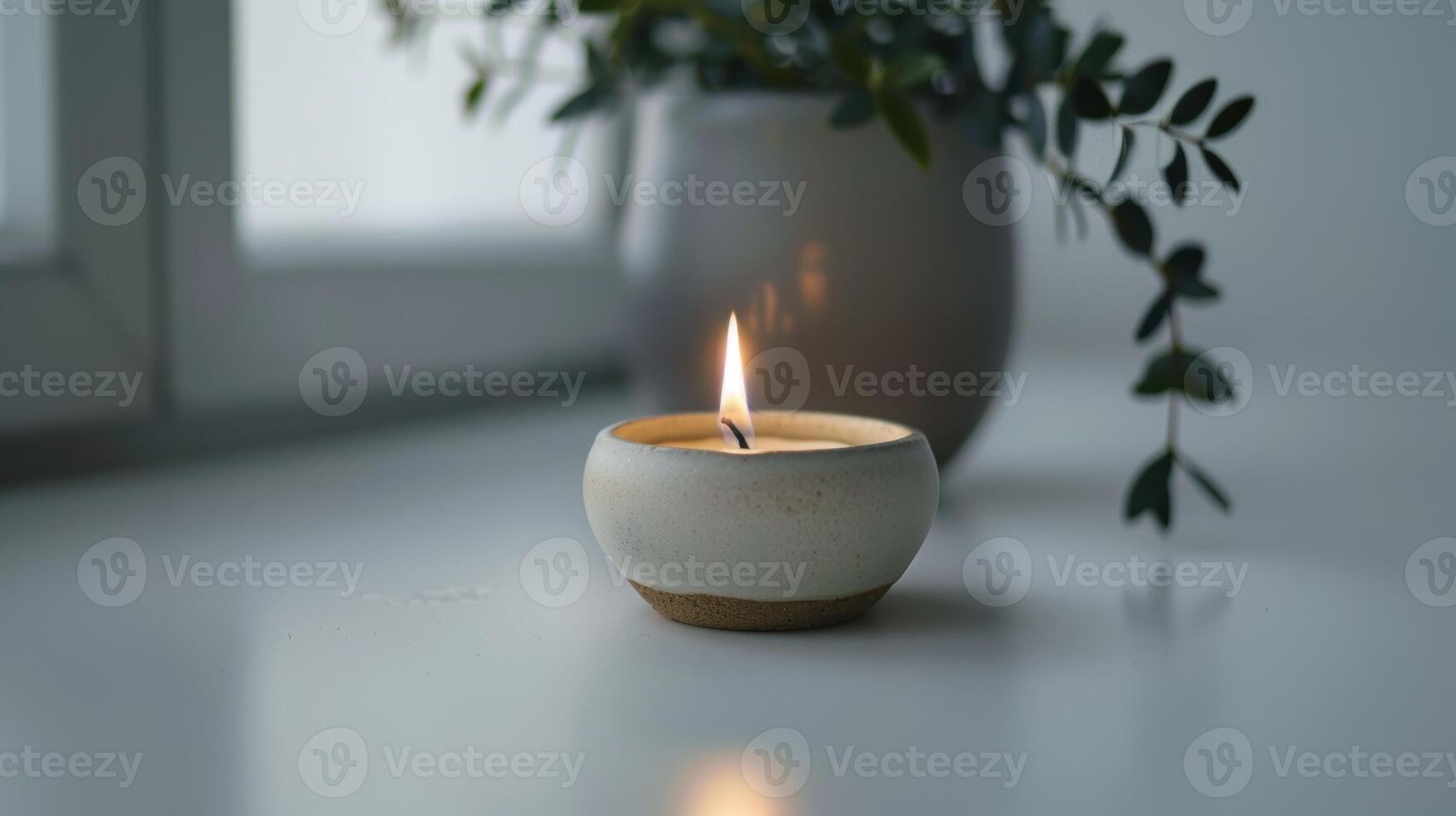 Handcrafted ceramic candle burns, creating a cozy glow and a peaceful ambiance photo