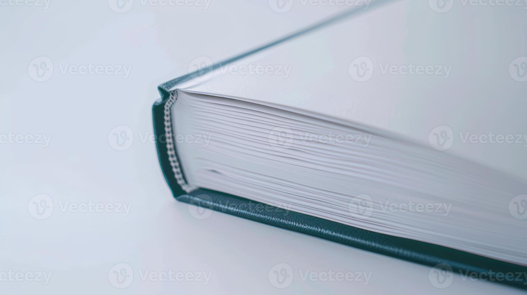 Green book with an open spine and binding on a white table, symbolizing wisdom and education photo