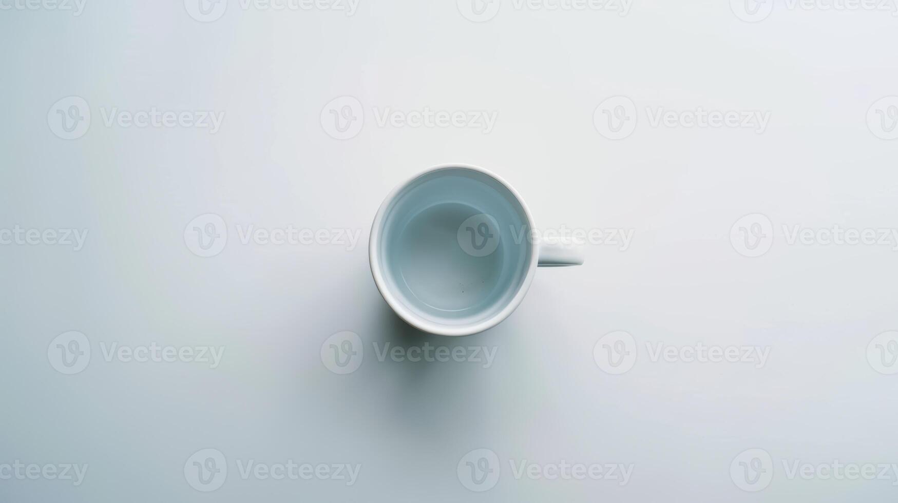 Simple white coffee mug rests on a white surface, creating a sense of minimalism and simplicity photo