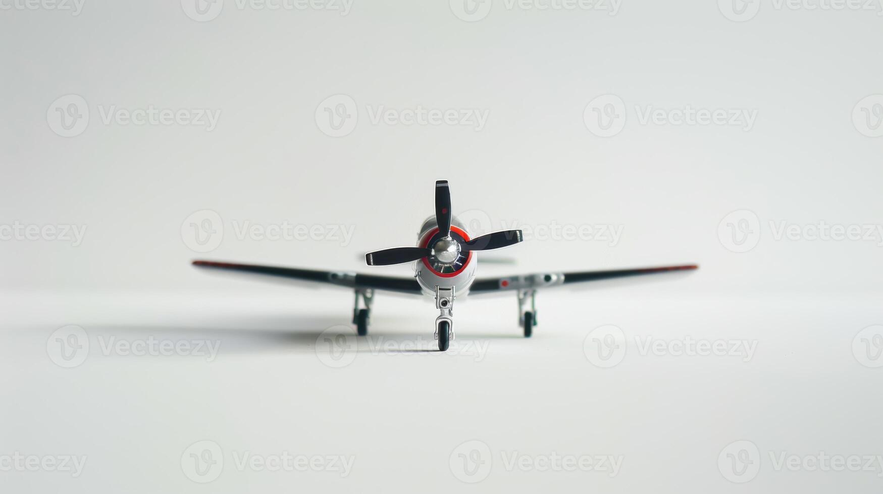 Toy airplane is placed on a white surface with its propeller facing forward photo