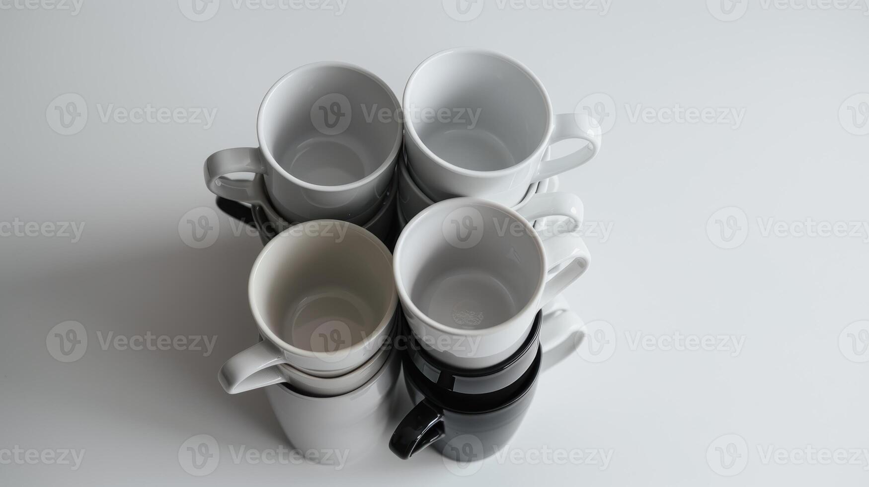 Stylish coffee mugs in black, white, and gray on a clean table, offering variety for morning drinks. photo