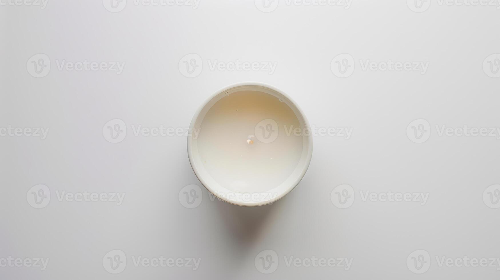 White scented candle illuminates a serene white setting, evoking a calming and peaceful ambiance photo