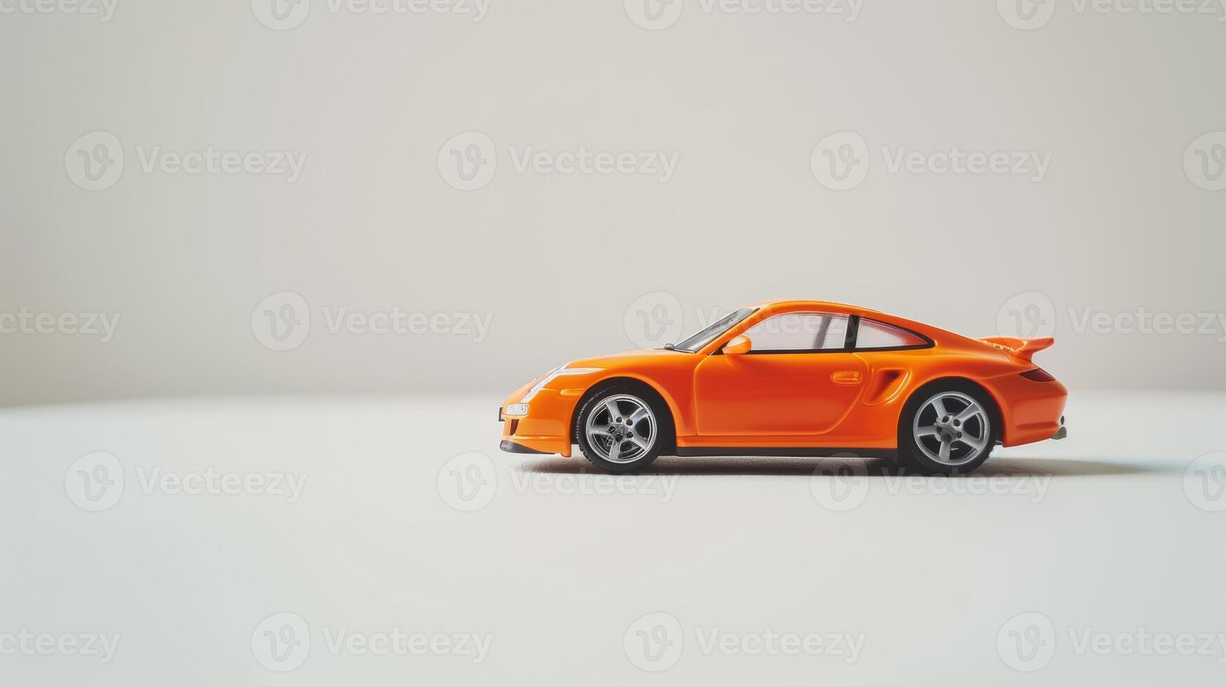 Vibrant orange toy car against a clean white background in a studio photo