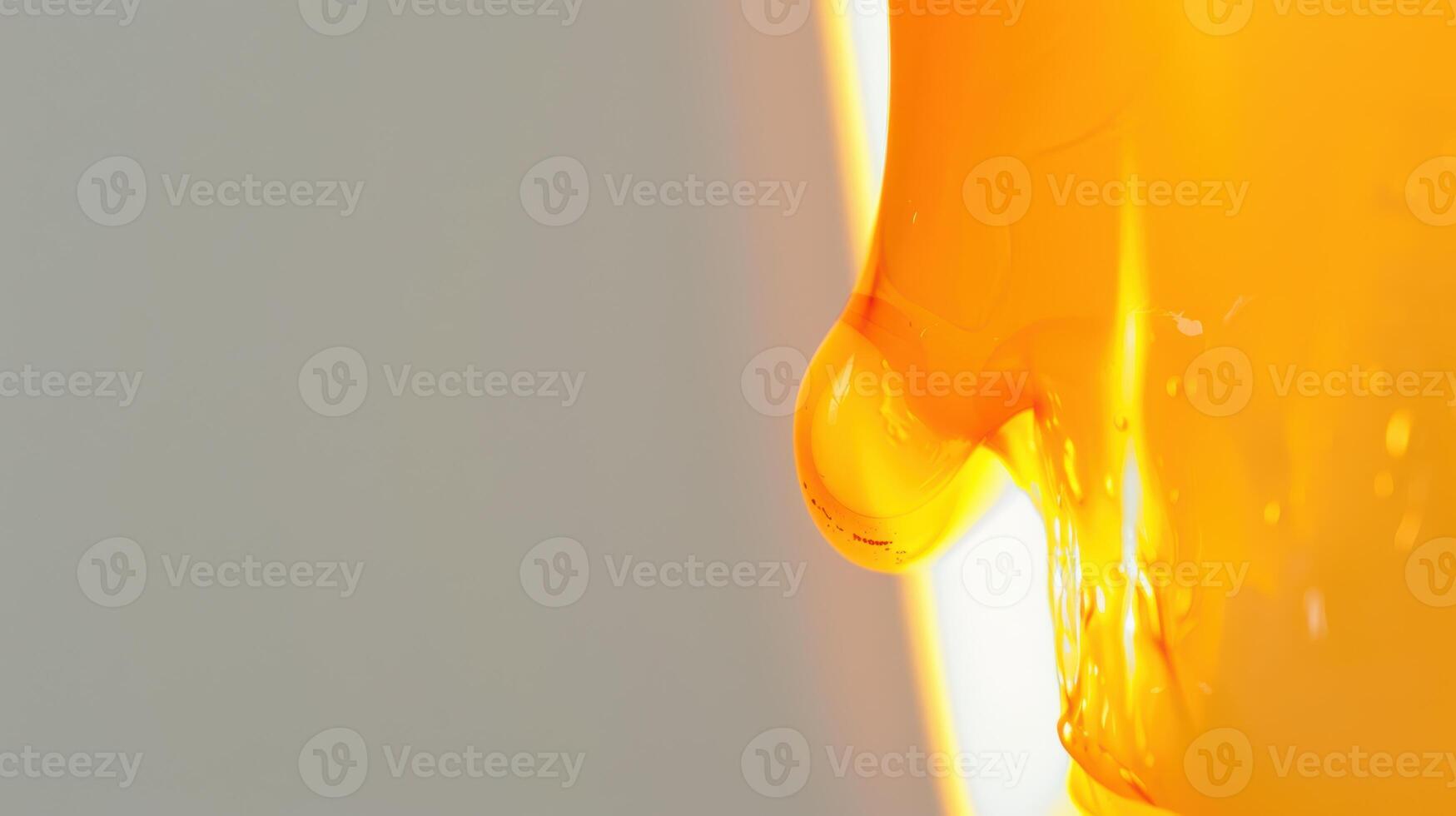 Golden honey dripping from a dipper, illuminated by sunlight in a close-up shot photo